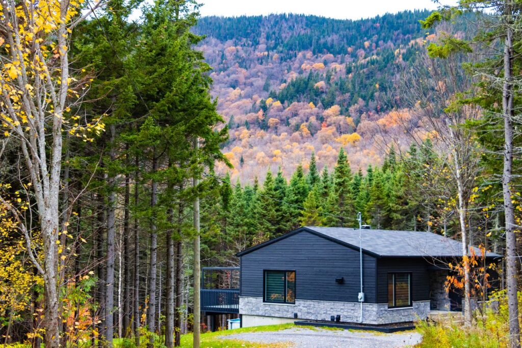 Peaceful cabin surrounded by vibrant fall foliage in Sainte-Brigitte-de-Laval, Quebec.